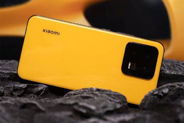 Флагман Xiaomi 13 в жёлтом и красном цвете позирует на живых фото